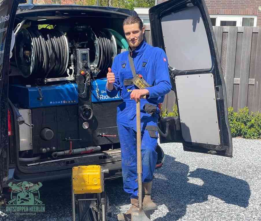 Een tevreden monteur met opgestoken duim naast de bestelbus, slim ingrijpen bespaart kosten bij een verstopte afvoer in Heerlen