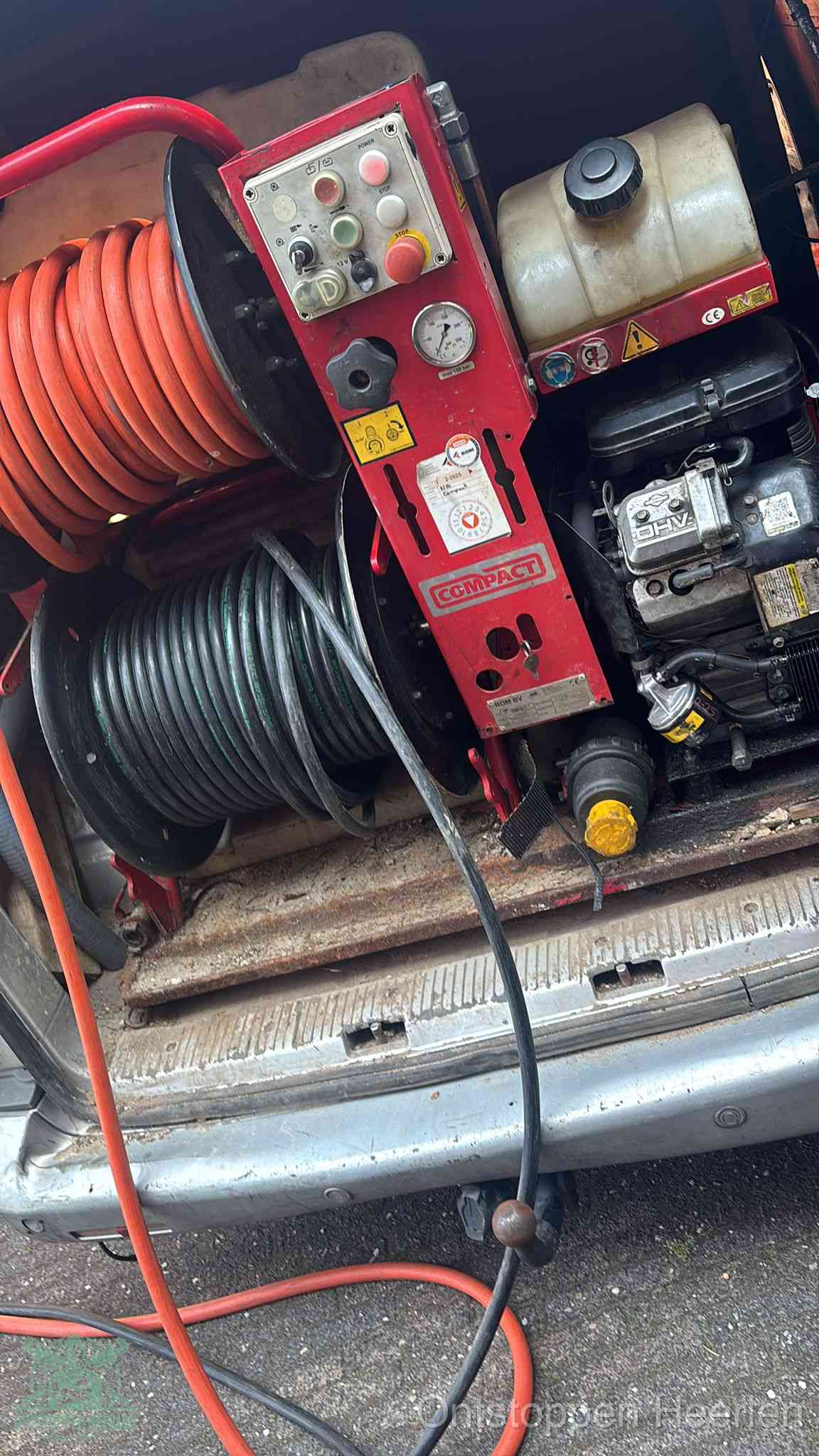 Een rood hogedruk-rioolreinigingstoestel in de laadbak van de bedrijfsbus, apparatuur voor een hardnekkige afvoerverstopping in Heerlen