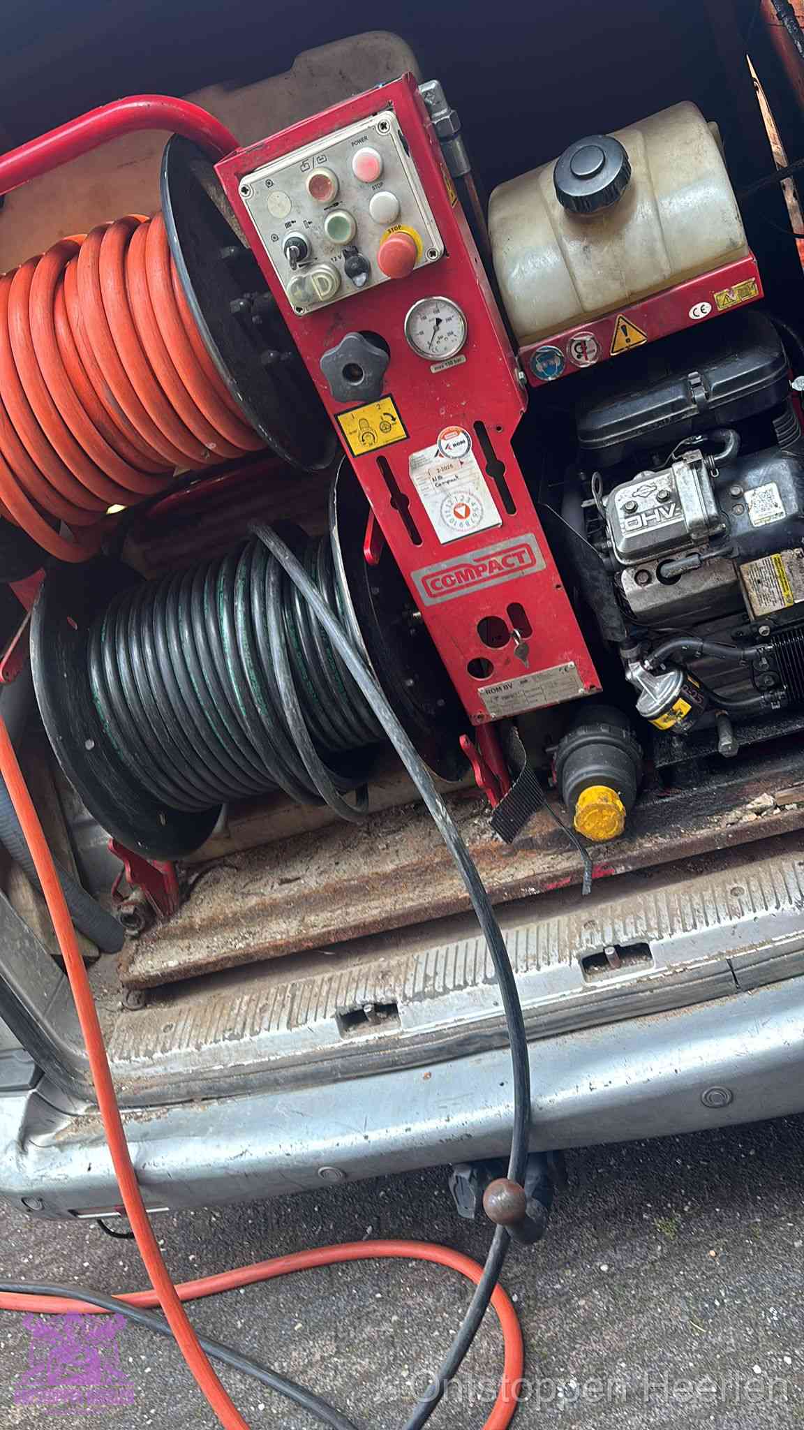 Een rood hogedruk-rioolreinigingstoestel met slangen in de laadbak van de bedrijfsbus, apparatuur voor een hardnekkige wc-verstopping in Heerlen
