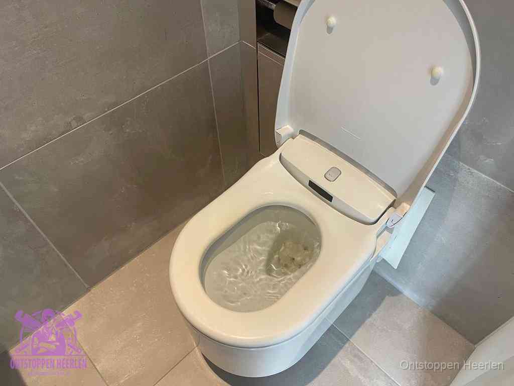 Een toiletpot vol troebel water met drijvend papier en restanten, de meest voorkomende oorzaak van een verstopte wc in Heerlen