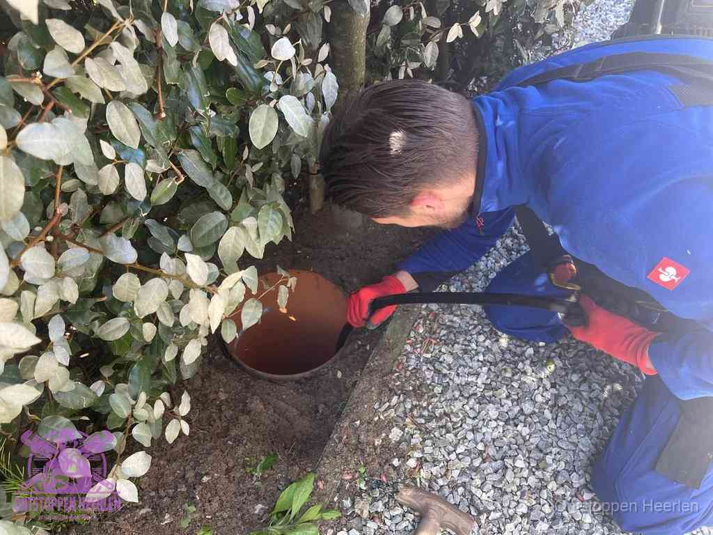 Monteur reinigt een rioolput met een slang, periodieke rioolreiniging in Heerlen