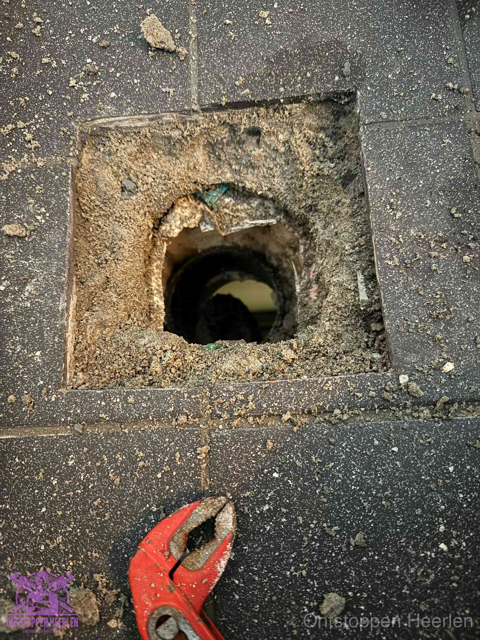 Geopend rioolputje op de erfgrens dat laat zien wie eigenaar is van de riolering in Heerlen