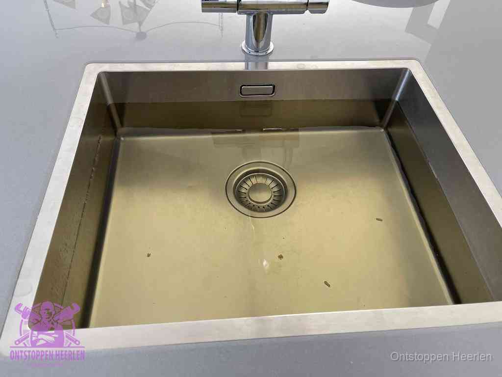 Stilstaand water in een rvs spoelbak dat niet wegloopt, een duidelijk signaal van een gootsteenverstopping in Heerlen