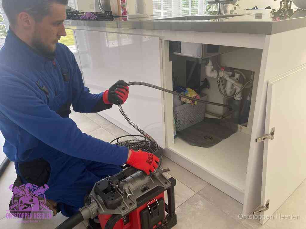 Een monteur reinigt de keukenafvoer grondig met een veermachine om terugkerende gootsteenverstoppingen te voorkomen in Heerlen
